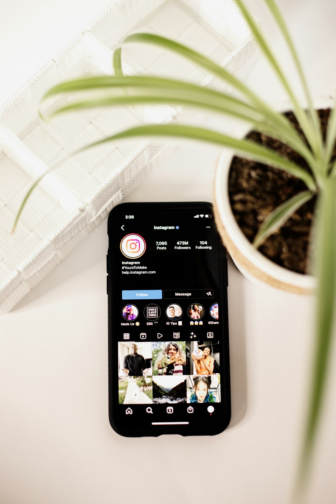 a-cell-phone-sitting-on-top-of-a-table-next-to-a-potted-plant-9qd8abqyj5w